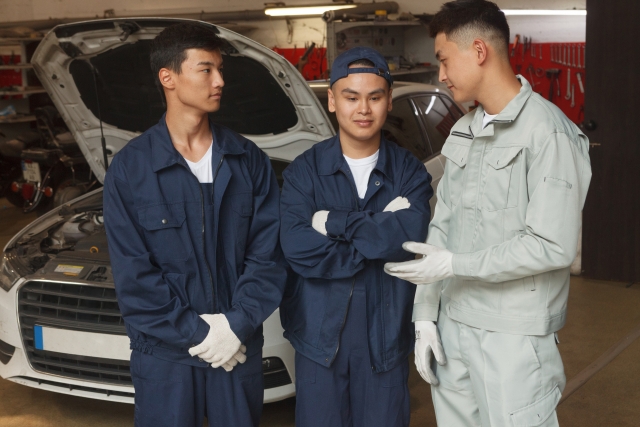 自動車整備の現場で指導を受ける実習生たち